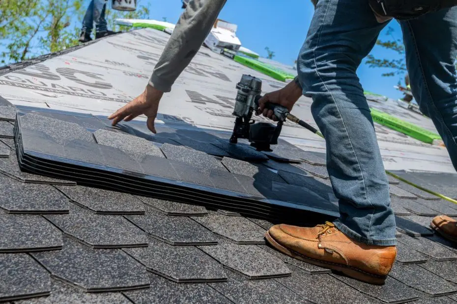 Roofing SEO: roofer kneeling on a pitched roof installing asphalt shingles