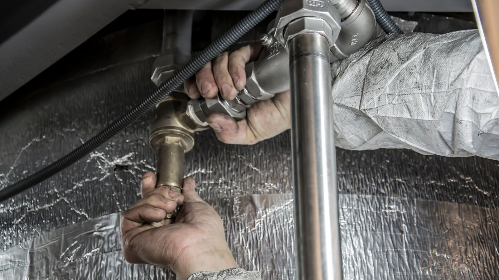 Plumber SEO: plumber's hands installing pipe fittings during a repair