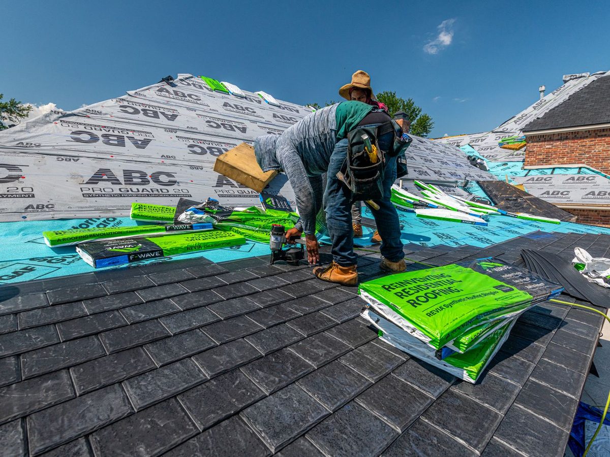 Roofing crew laying shingles over underlayment on a new roof